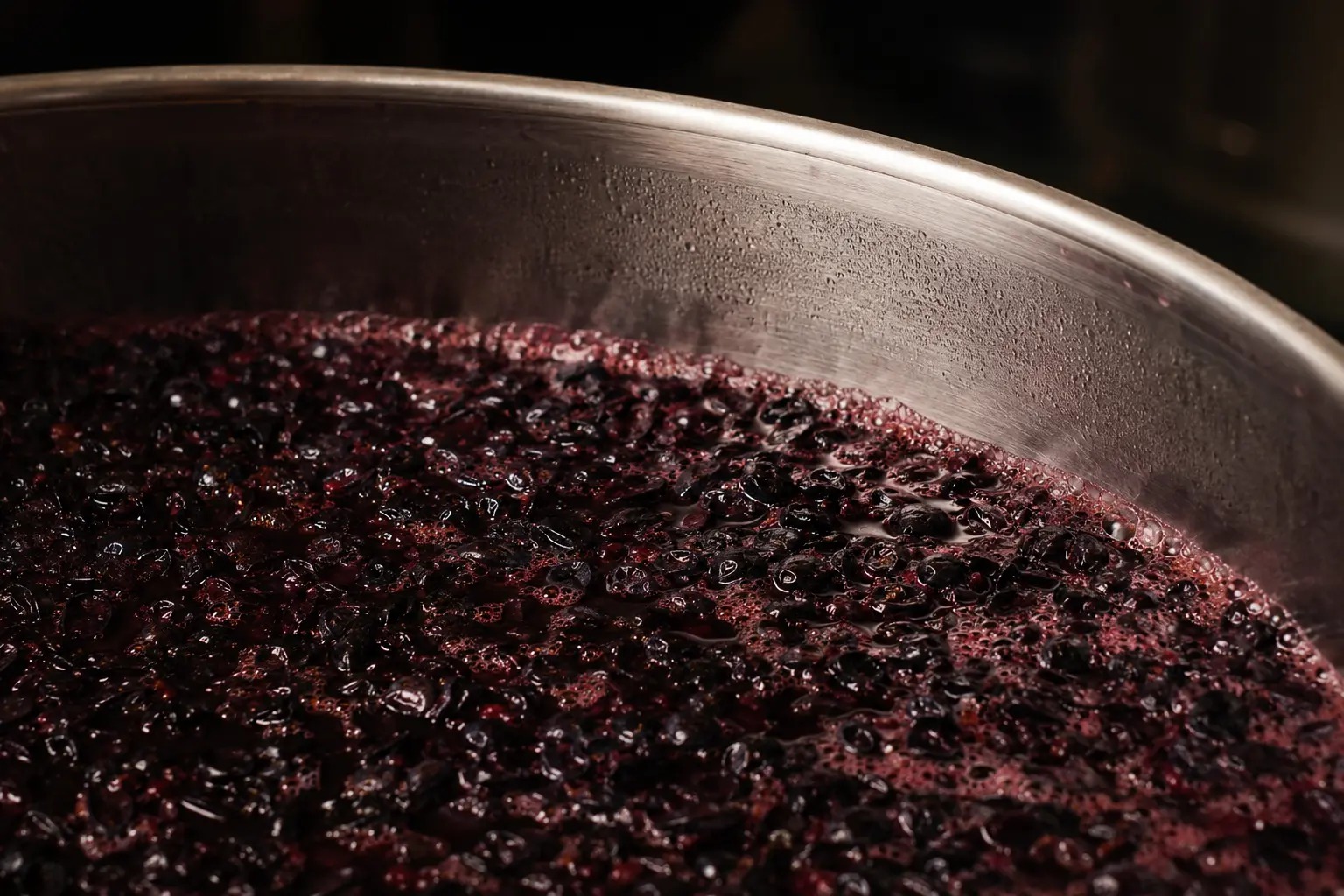 Uva tinta en fermentación dentro de un recipiente de acero